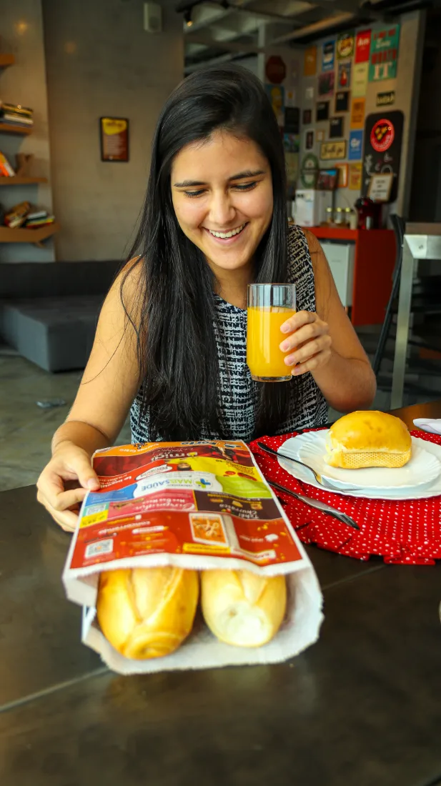 Consumidora com o saquinho e o café da manhã em casa
